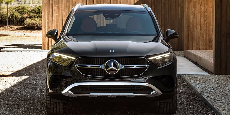 Front view of a black Mercedes-Benz SUV parked in front of a modern wooden building