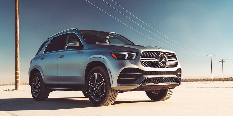 Silver Mercedes-Benz SUV parked on an open road under a clear blue sky