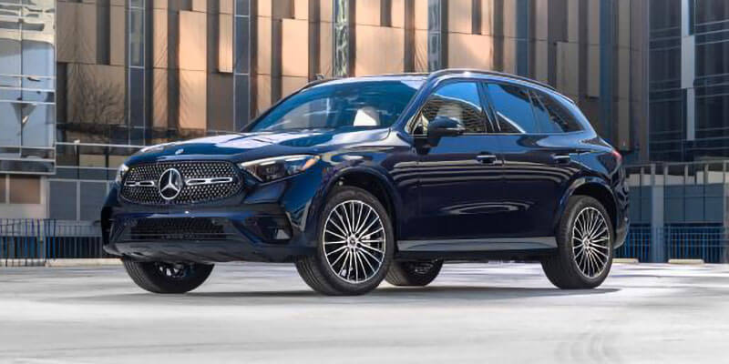 Dark blue Mercedes-Benz SUV parked in front of modern office buildings in an urban setting